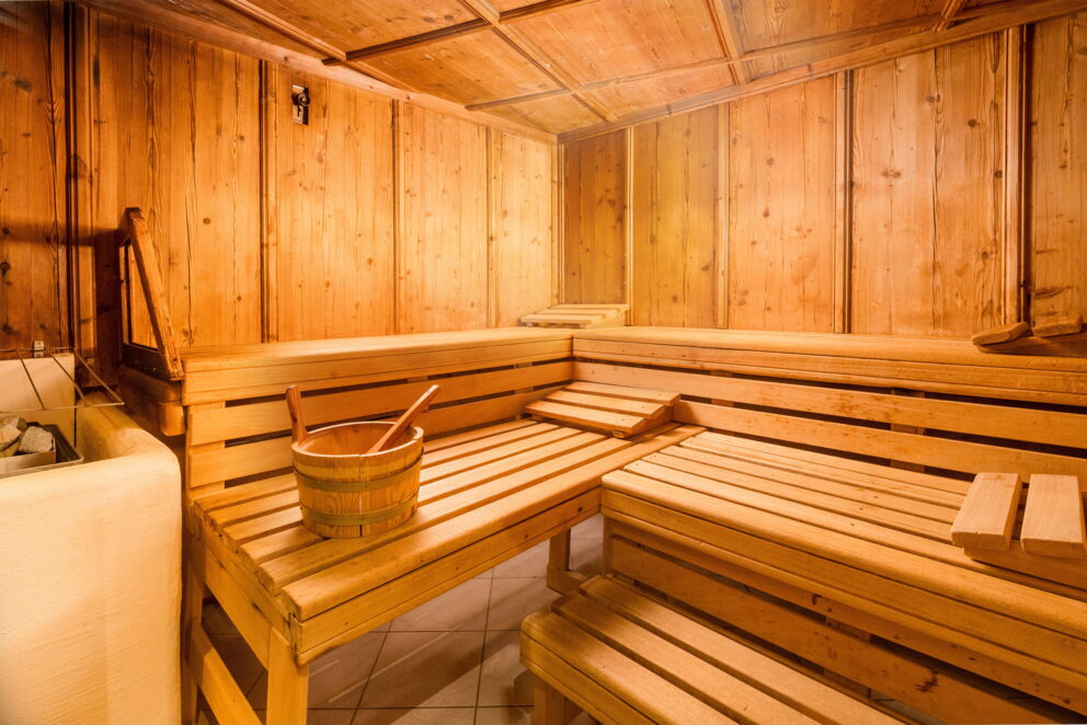 Gemütliche Sauna mit Holzbänken und Saunaeimer für entspannende Wellness-Momente.