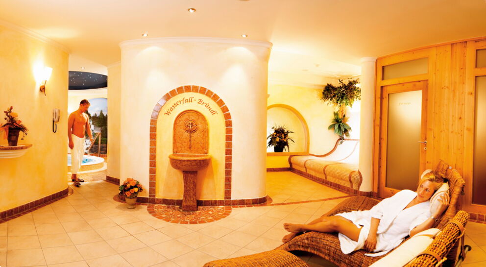 Wohlfühlbereich mit Wasserfallbrunnen und gemütlichen Liegen im Hotel Klockerhaus.
