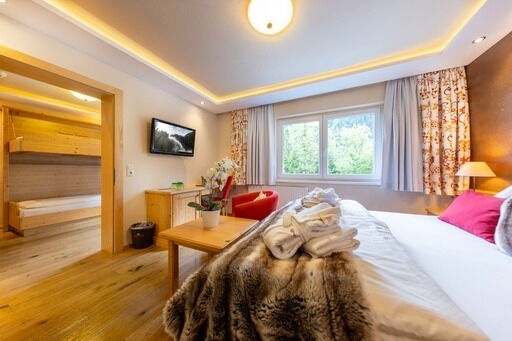 Helles Zimmer mit Doppelbett, weichen Textilien und Blick ins Grüne