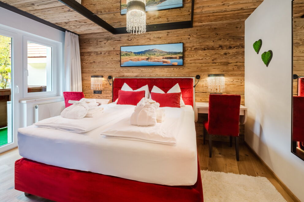 Schlafzimmer des Kuschelzimmers mit Doppelbett, Holzverkleidung und natürlichem Licht