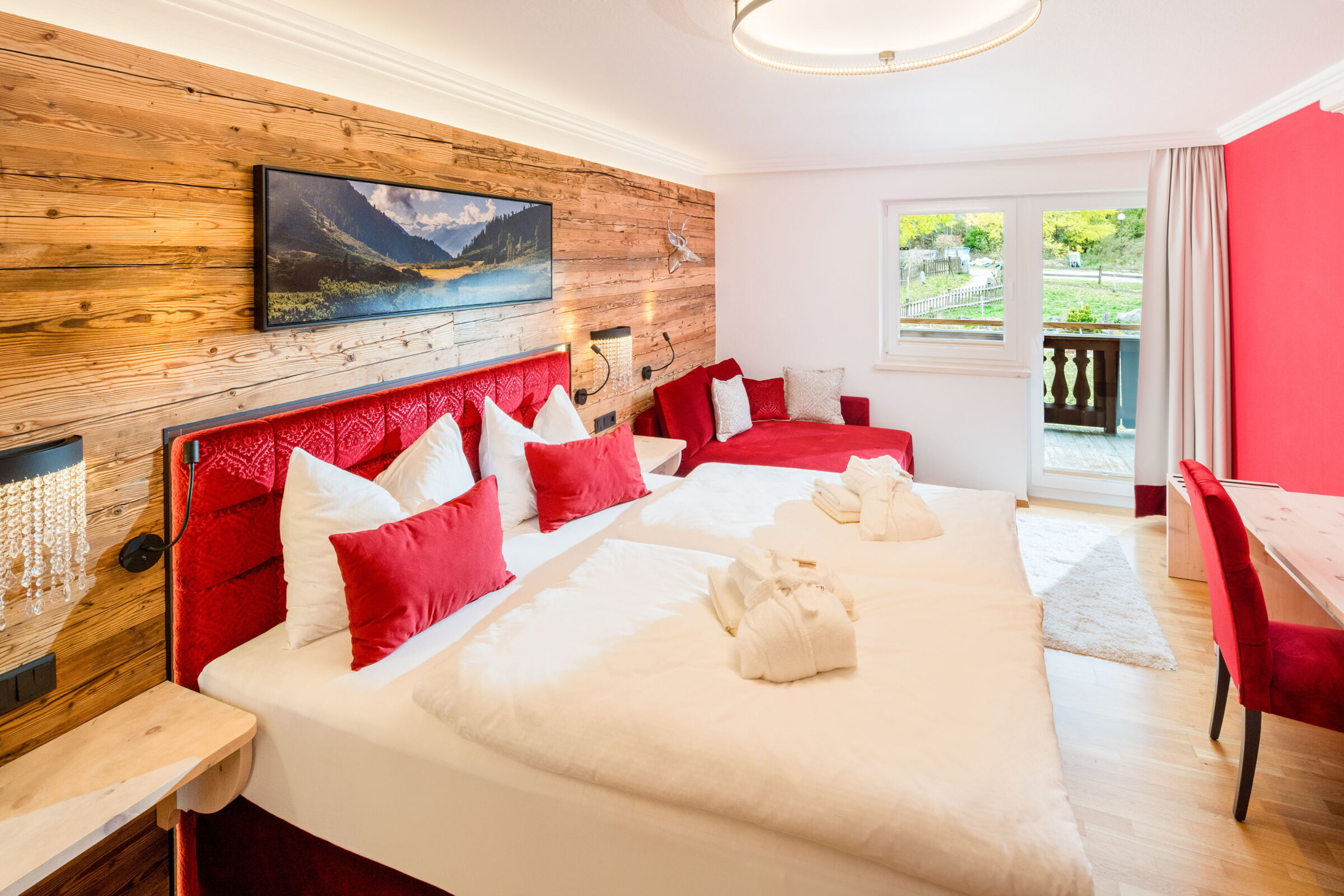 Schlafzimmer der Kuschelsuite "Superior" mit Doppelbett und rotem Design