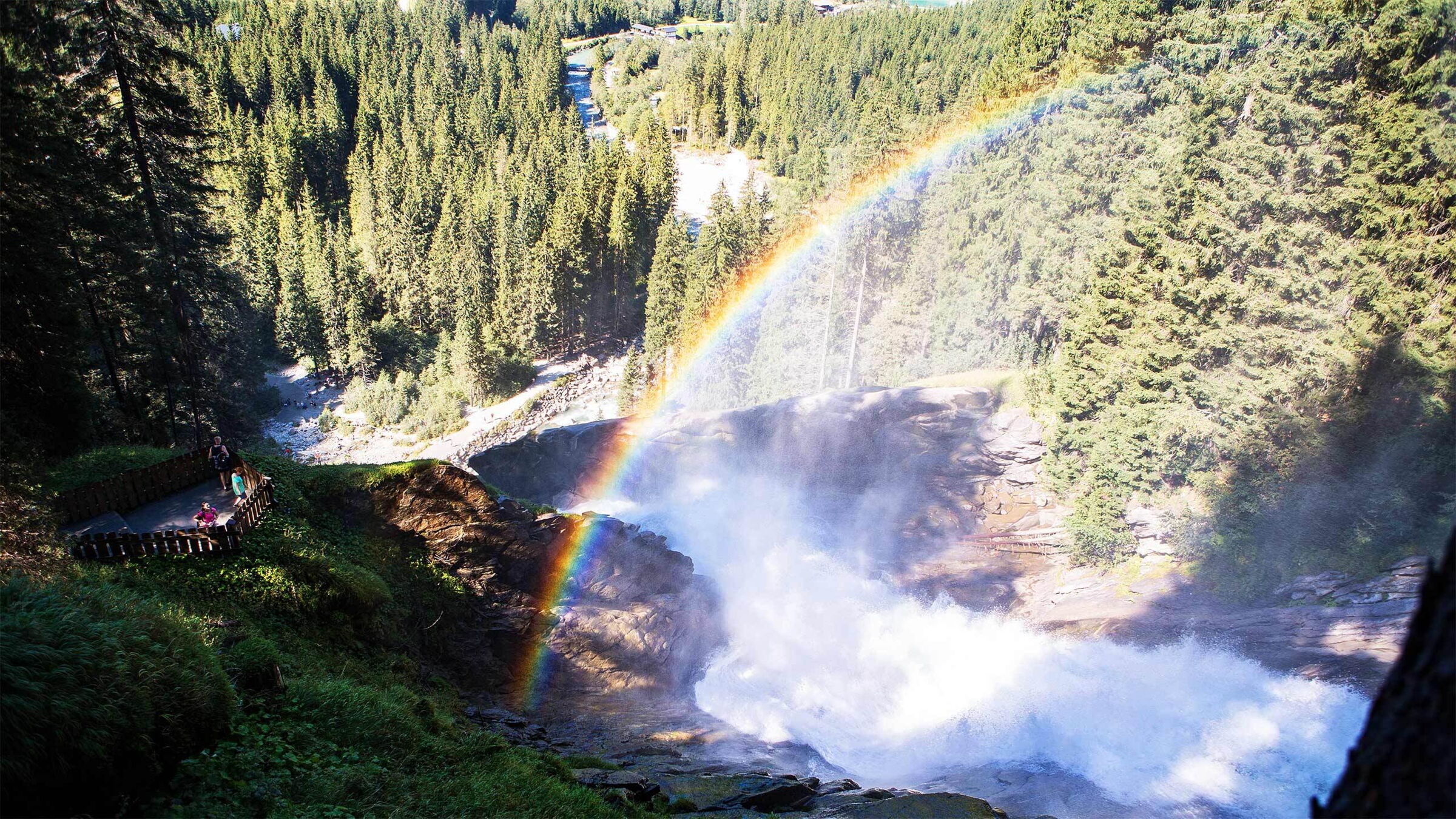 Regenbogen über den Krimmler Wasserfällen im üppigen Wald des Nationalparks Hohe Tauern.
