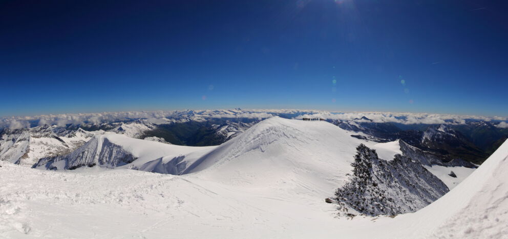Schneebedeckte Berggipfel unter klarem, strahlend blauem Himmel in den Alpen.