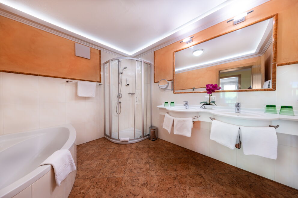 Helles Badezimmer mit großer Badewanne, Dusche, Doppelwaschbecken und stilvollen Details.