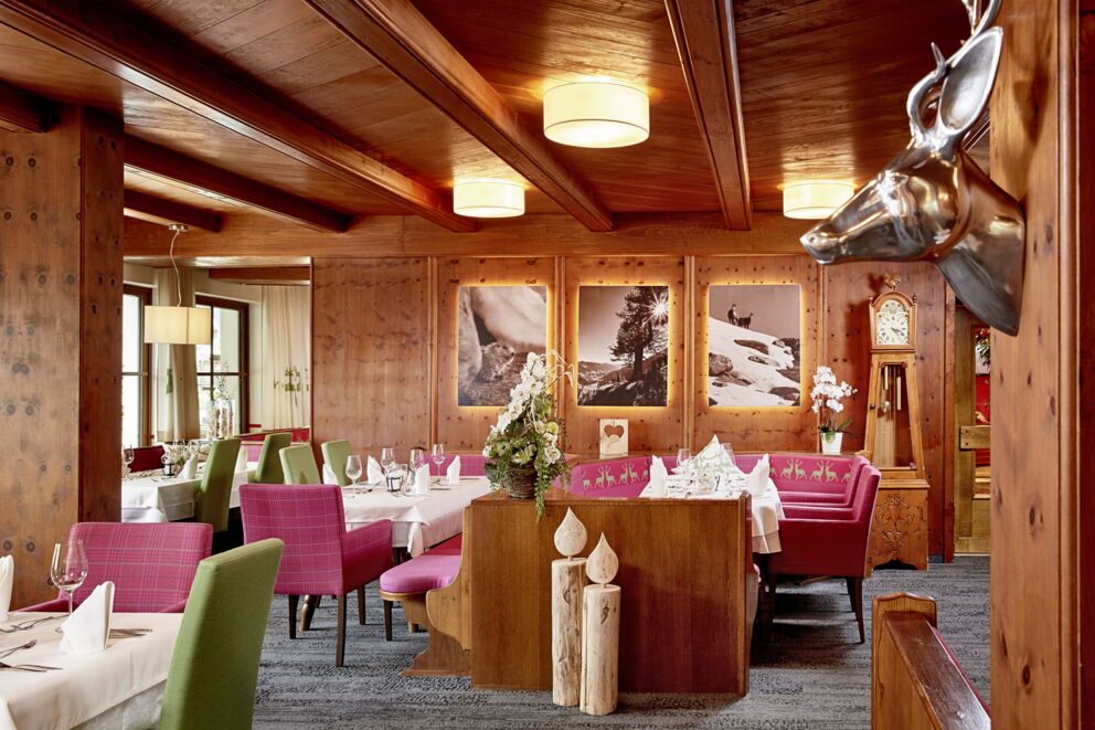 Elegantes Restaurant mit Holzmöbeln, Kunstwerken und stilvoll gedeckten Tischen.