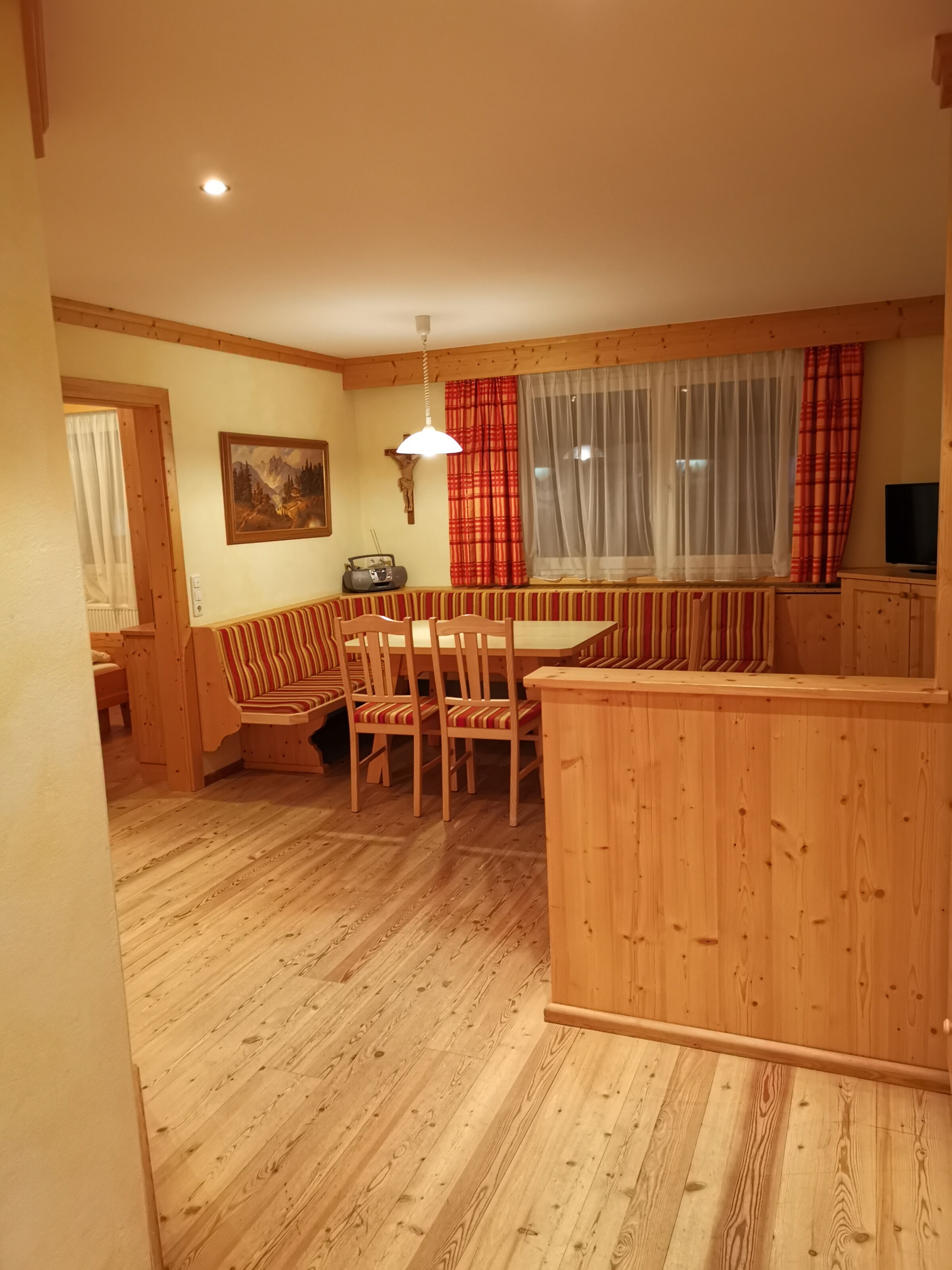Inviting wooden seating area with table, surrounded by warm wood tones and works of art.
