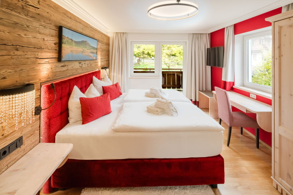 Schlafzimmer der Kuschelsuite "Superior" mit Doppelbett und moderner Holzwand